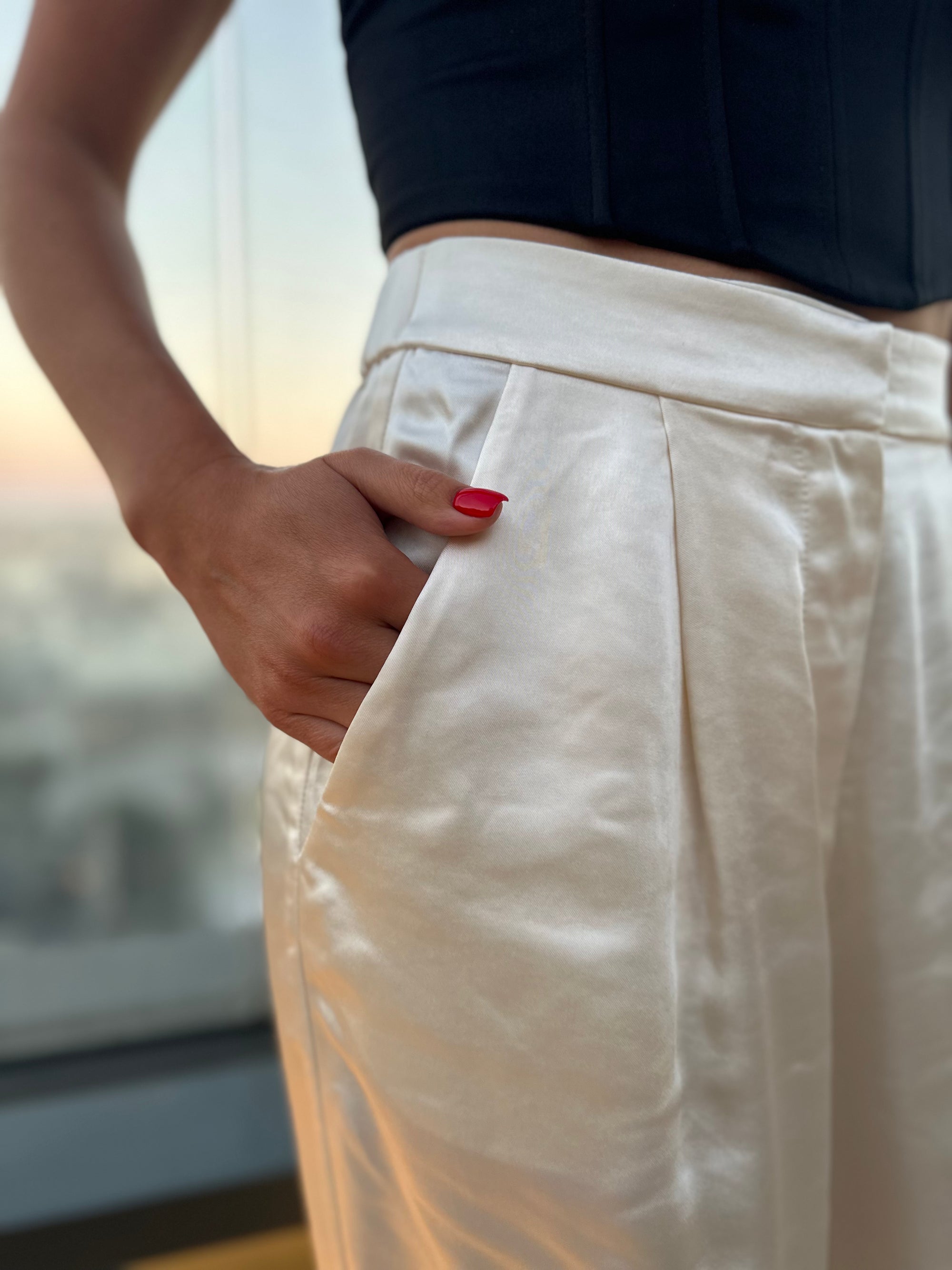 Close-up of ivory satin fabric texture and waistband detail