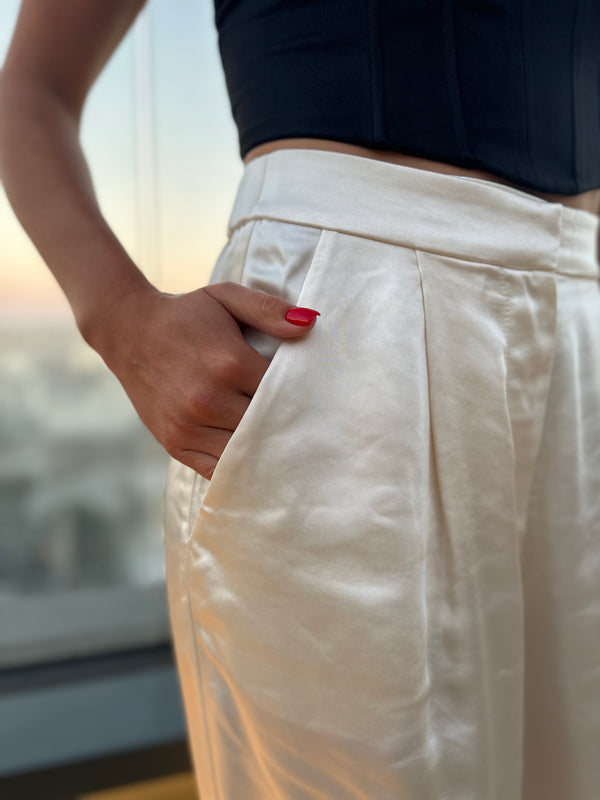 Close-up of ivory satin fabric texture and waistband detail