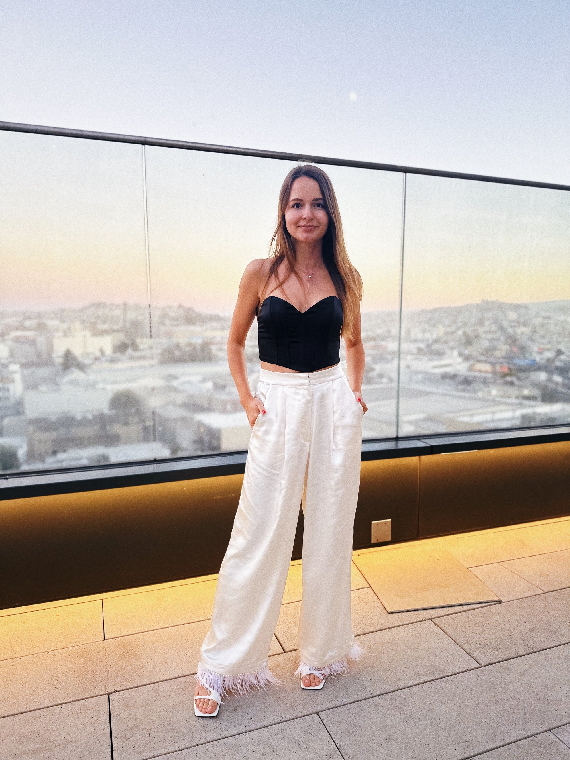 Model walking in ivory satin pants, capturing movement and shine