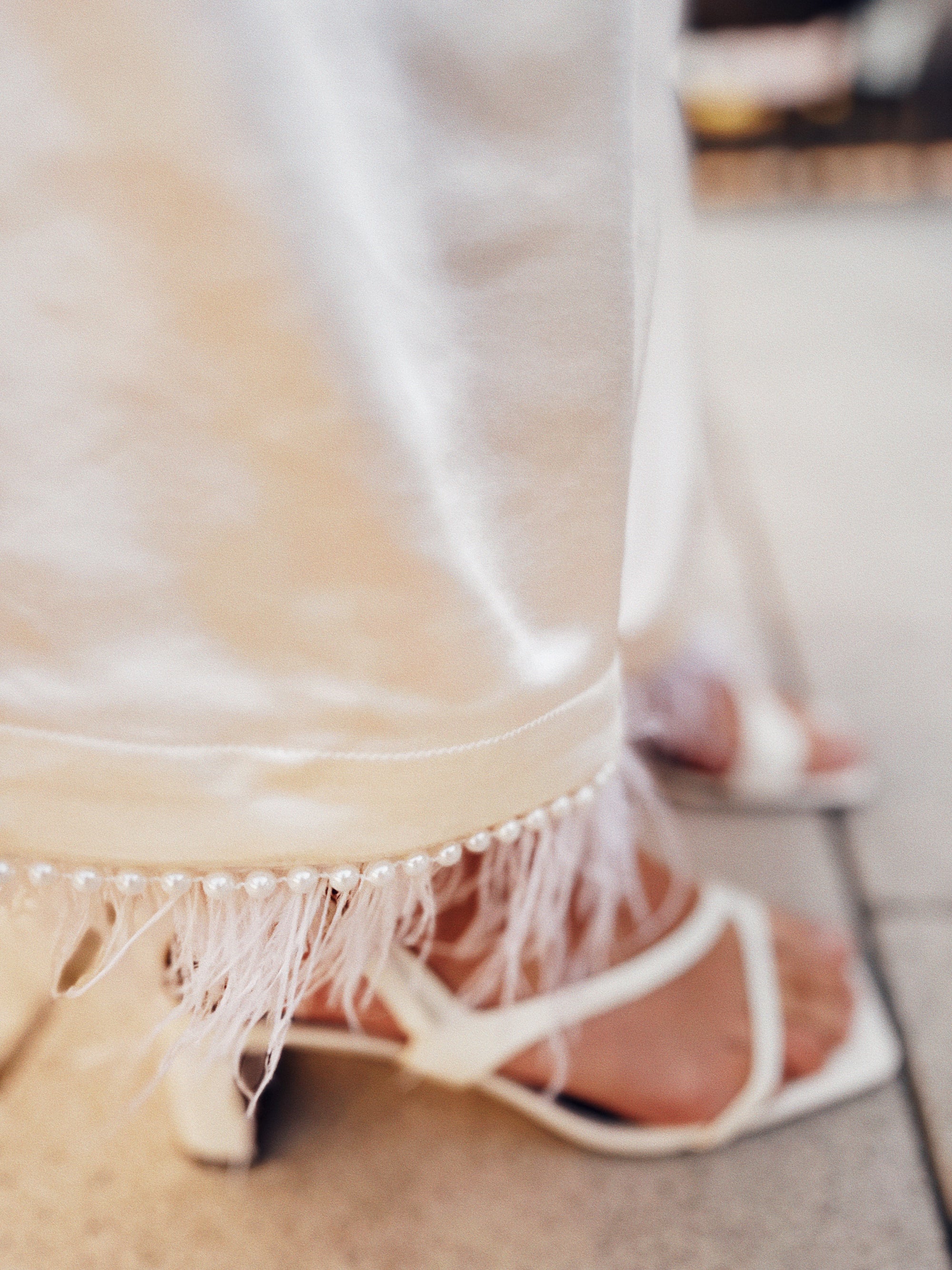 Close-up of ivory satin fabric texture and waistband detail